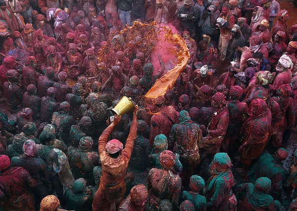 A man throws coloured water as he celebrates Lathmar Holi at Nandgaon
