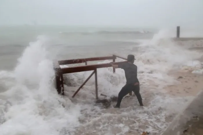 Framed Print : A man tries to salvage a table belonging to his restaurant before the arrival of Framed Print : A man tries to salvage a table belonging to his restaurant before the arrival of