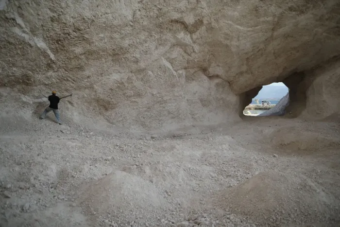 Framed Print : A man uses a pick to break rocks and get sand in a sand mine on the outskirts of Fond Framed Print : A man uses a pick to break rocks and get sand in a sand mine on the outskirts of Fond