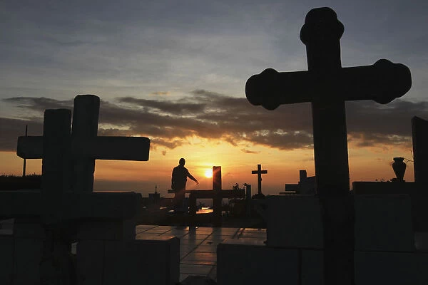 A man visits graves of his relatives in a cemetery in Managua