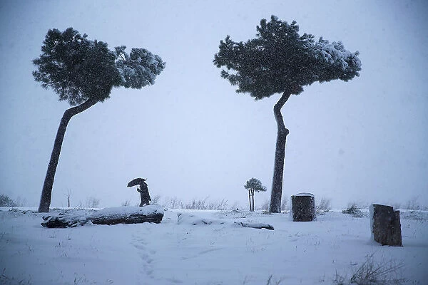 A man walks during a heavy snowfall in downtown Rome