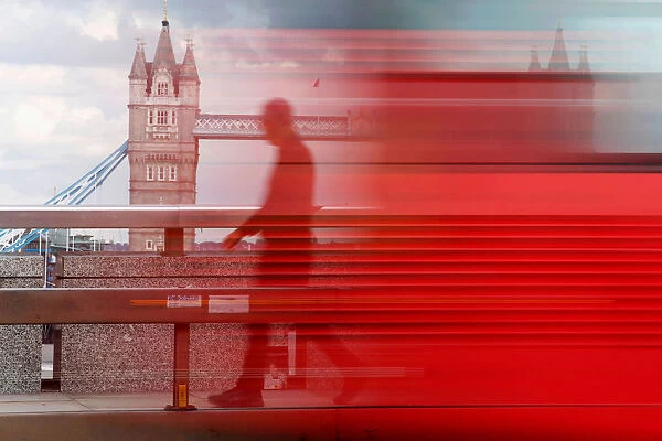 A man walks across London Bridge behind a barrier to prevent traffic mounting the