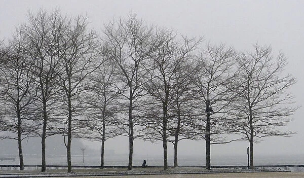 A man walks in a park along the Hudson River across from Manhattan in Hoboken, New Jersey