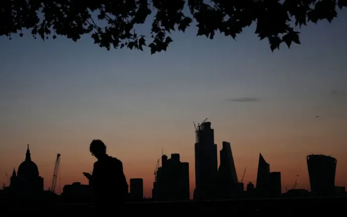 Framed Print : A man walks past the city of London financial district as dawn breaks in London Framed Print : A man walks past the city of London financial district as dawn breaks in London
