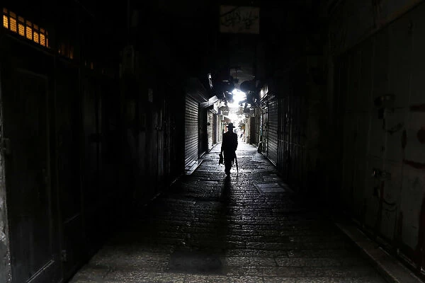 A man walks past closed shops as Palestinian political parties call for a general strike