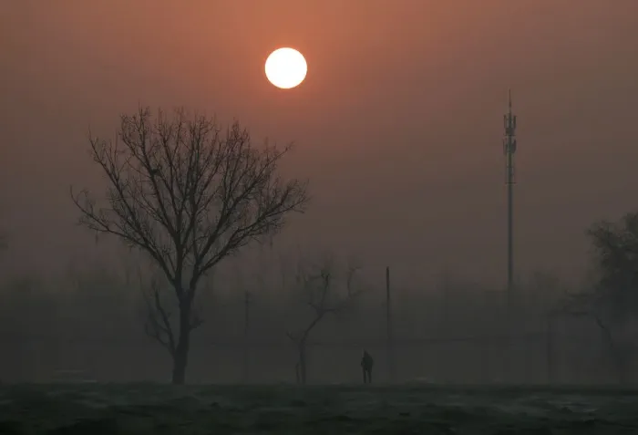 Framed Print : A man walks during sunrise in smog as a red alert issued for air pollution in Beijing