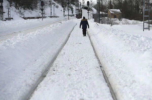 A man walks on the train tracks in Busdongo