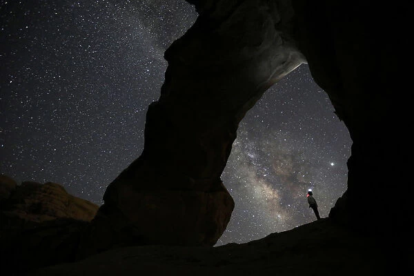 A man watches the stars seen on the sky of Al-Kharza area of Wadi Rum in the south of
