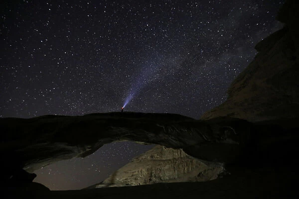 A man watches the stars seen on the sky of Al-Kharza area in Wadi Rum in the south of