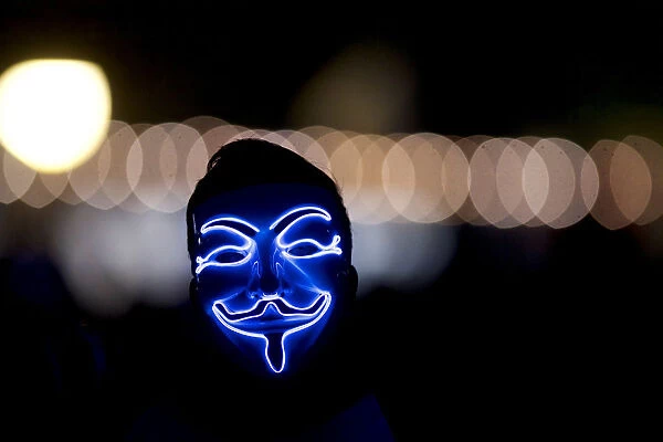 A man wears an anonymous mask on the fourth and final day of the Firefly Music Festival