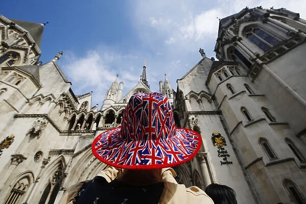 A man wears a hat printed with Union Flags outside the Royal Courts of Justice in London