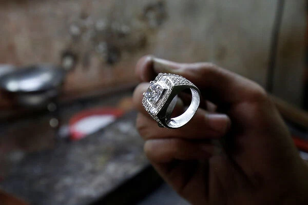 A man works on a silver ring at a workshop in Hanoi
