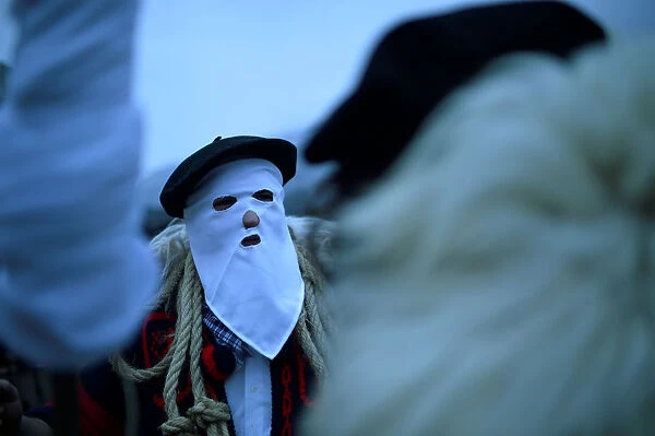A masked man wearing a Basque beret takes part in carnival celebrations in Alsasua