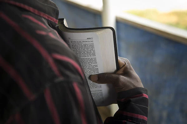 A member of the clergy reads from the Bible to Ebola Patients in the recovery wing of the