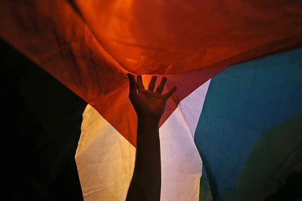 A member of the Palestinian community in Chile holds up a Palestinian flag during a