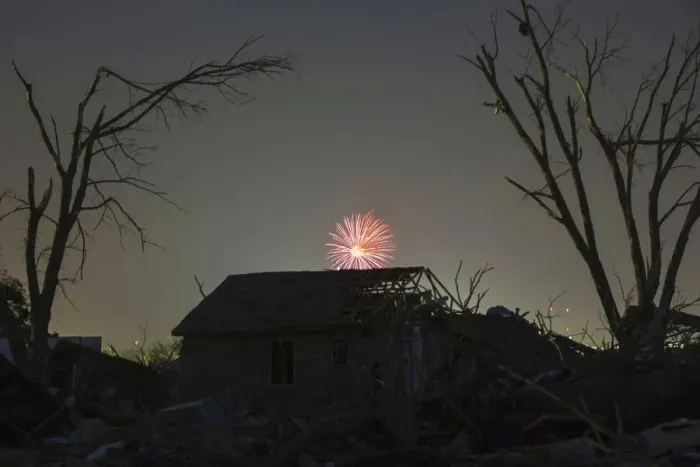 Framed Print : Memorial Day fireworks explode over a house damaged by the May 20 afternoon tornado in