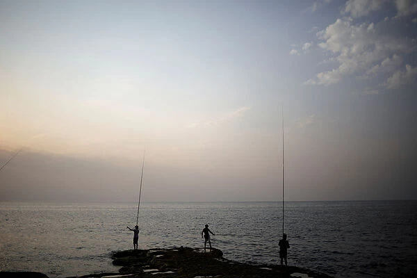 Men fish from the shore in Beirut
