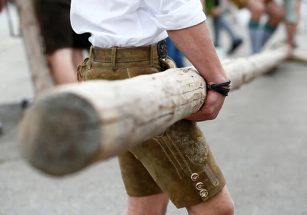 Men in traditional Bavarian clothes erect a maypole in Germerswang