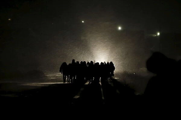 Migrants walk along a road after crossing the border from Macedonia, at Miratovac, Serbia