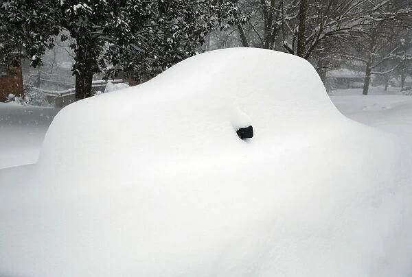 A mirror is all that can be seen of a snow covered car in Falls Church, Virginia