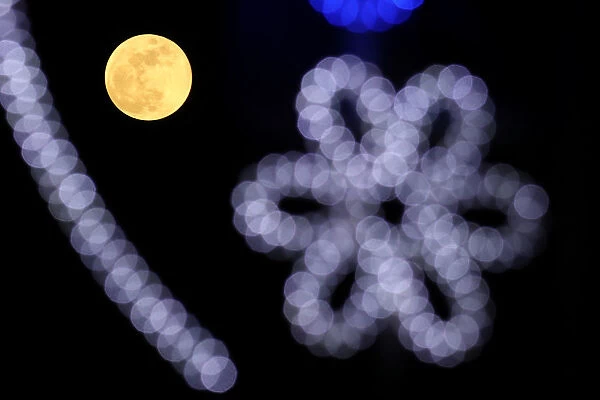 A full moon rises behind Christmas decorations in Belgrade