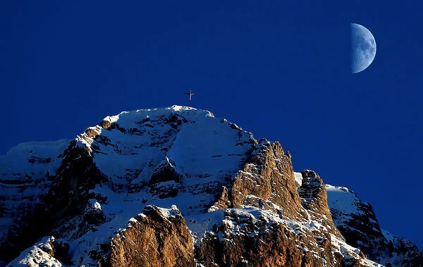 The moon rises over the Dolomites alps in Gardena pass in Val Gardena