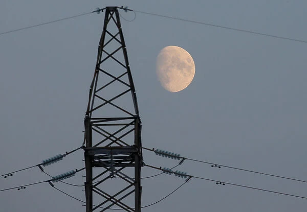 The moon rises behind a power line near the Chernobyl Nuclear Power Plant in Chernobyl