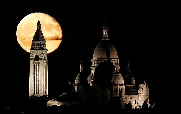 The moon rises over the Sacre Coeur Basilica in Montmartre in Paris