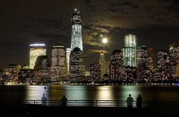 The moon rises behind the skyline of New Yorks Lower Manhattan and One World Trade