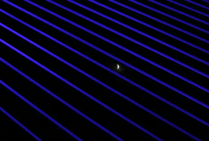 Framed Print : The moon is seen during the beginning of a total lunar eclipse through the structures of Framed Print : The moon is seen during the beginning of a total lunar eclipse through the structures of