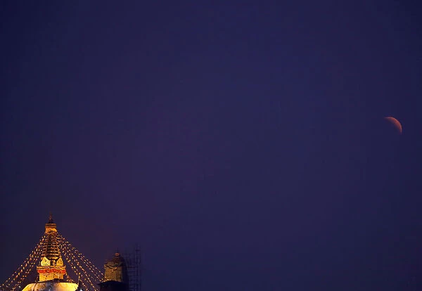 A full moon is seen during the lunar eclipse as it rises behind the Swayambhunath Stupa