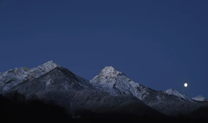 Framed Print : The moon is seen over the mountain ahead of the womens parallel giant slalom competition Framed Print : The moon is seen over the mountain ahead of the womens parallel giant slalom competition