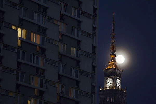 The moon is seen above the Palace of Culture and Science in the center of Warsaw