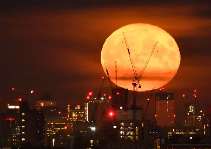 Framed Print : The full moon is seen rising behind skyscrapers at Canary Wharf and the London skyline Framed Print : The full moon is seen rising behind skyscrapers at Canary Wharf and the London skyline