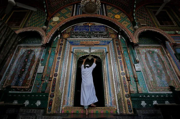 Framed Print : A Muslim man touches an ornament, engraved with verses from the Koran