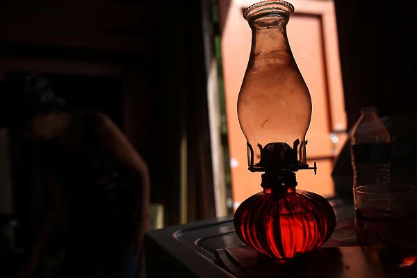 Oil lamp is seen on top of washing machine at Perez home, in Naguabo