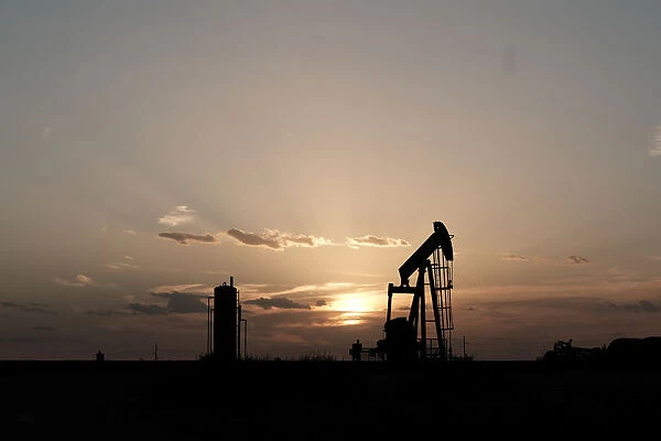 Oil pump jacks work at sunset near Midland