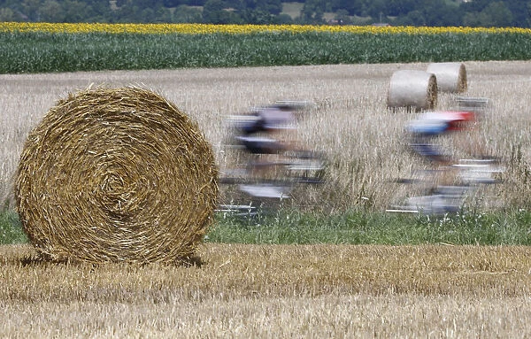 The pack of riders cycles on its way during the 197. 5km 13th stage of the Tour de France
