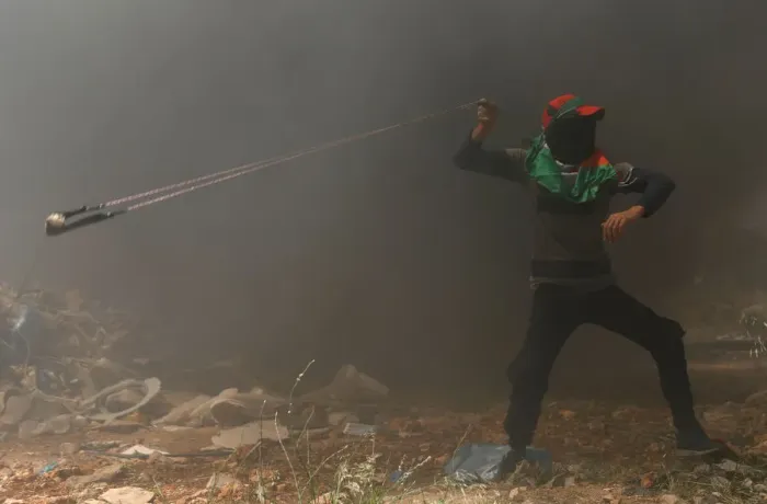Framed Print : Palestinian demonstrator uses a sling to hurl stones at Israeli troops during a protest Framed Print : Palestinian demonstrator uses a sling to hurl stones at Israeli troops during a protest