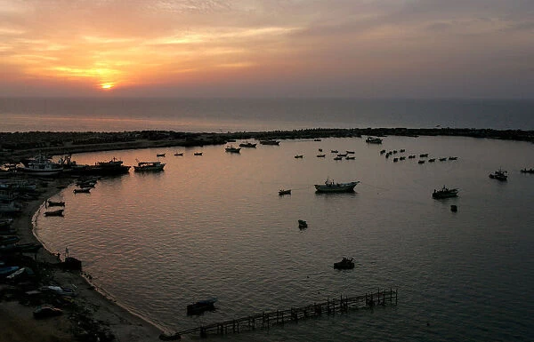 Palestinian fishermen are seen fishing during the last sunset of the year in Gaza