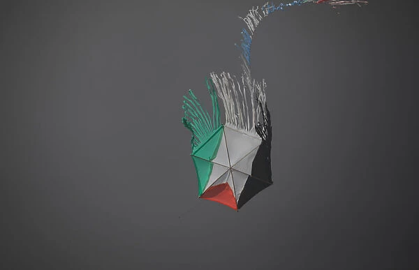 A Palestinian kite is seen in the smoke-darkened skies between Israel