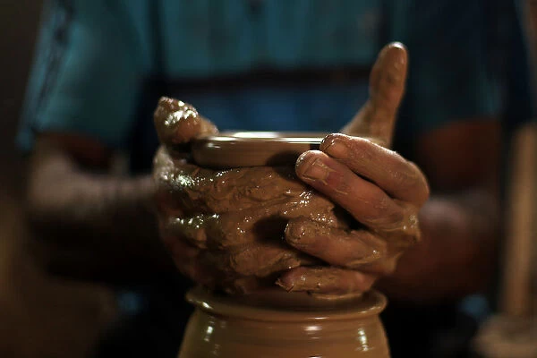 Palestinian worker makes clay pots at a pottery workshop in Gaza City