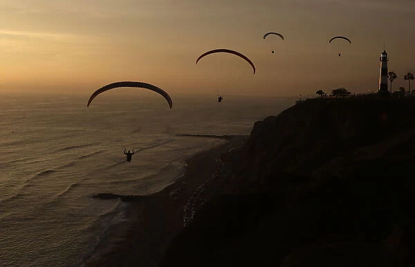 Paragliders fly in front of Limas Miraflores district