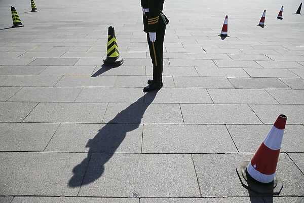 Paramilitary policeman stands guard in front of the Great Hall of the People before