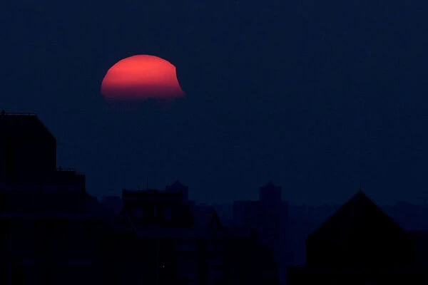 A partial eclipse of the sun, as it sets, is seen from Shanghai