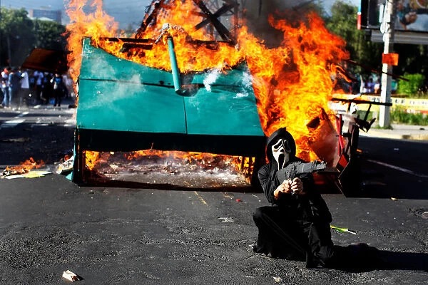 A participant reacts in front of a mock-up tank on fire as university students