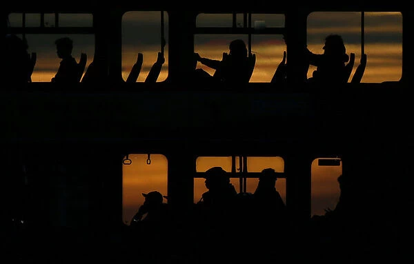Passengers travel on a bus during sunset in London