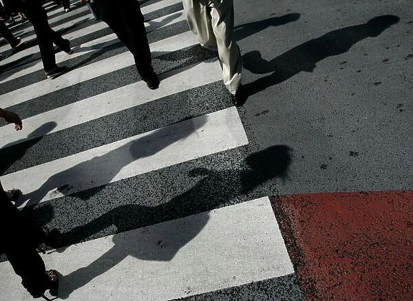 Pedestrians cross the road on a zebra crossing in the Shibuya shopping district in Tokyo