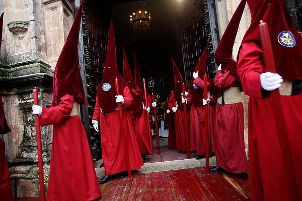 Penitents leave a church as they take part in a procession during the Holy Week in Ronda