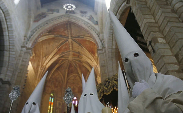 Penitents take part in the procession of La Borriquita brotherhood during Holy Week in